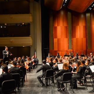 TCU maestro German Gutierrez directs a large group of musicians onstage at Bass Hall