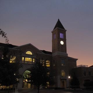 The clock tower at TCU's Brown Lupton University Union glows at dusk